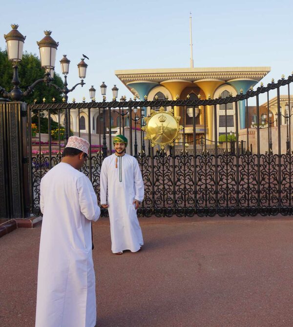 Zwei Omanis machen Fotos vor dem Sultan-Palast - interkulturelle Kompetenz entscheidet